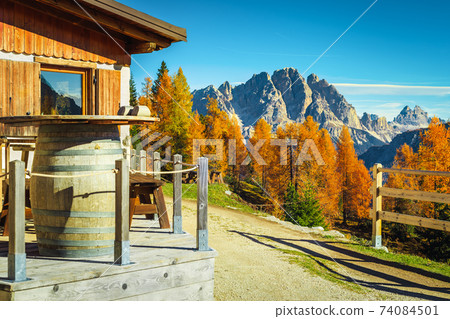 Wooden house with terrace in the colorful autumn forest, Dolomites 74084501