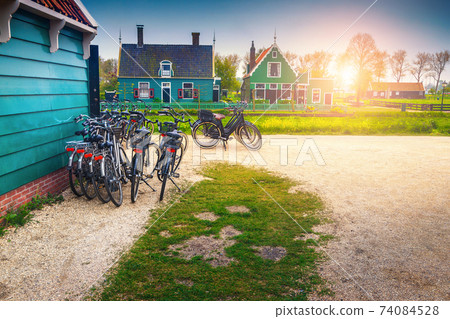 Tourist bicycles and cute wooden houses in Zaanse Schans, Netherlands  Tourist bicycles and cute wooden houses in Zaanse Schans, Netherlands  74084528