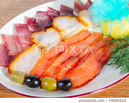 Set of several varieties of dried fish on a plate with lemon and olives Set of several varieties of dried fish on a plate with lemon and olives 74084828