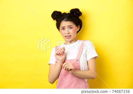 Stay away. Reluctant timid asian girl step back, raising hands to block something disgusting, grimacing displeased, say no, rejecting with aversion, yellow background Stay away. Reluctant timid asian girl step back, raising hands to block something disgusting, grimacing displeased, say no, rejecting with aversion, yellow background 74087156