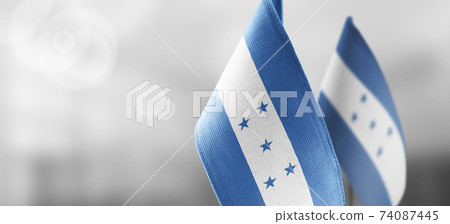 Small national flags of the Honduras on a light blurry background 74087445