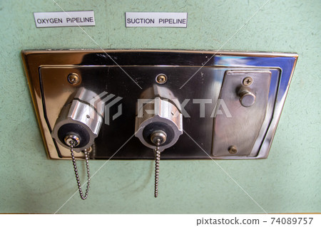A oxygen and sunction plug sockets on the wall in a hospital patient room, close up. 74089757