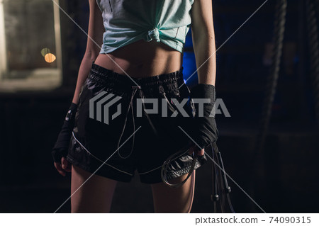 Young girl stands in an atmospheric gym. Close-up of a girl's stomach Young girl stands in an atmospheric gym. Close-up of a girl's stomach 74090315