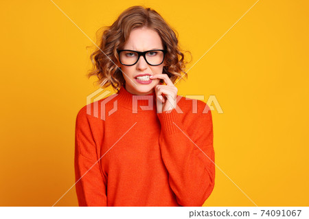 nervous young woman biting nail 74091067