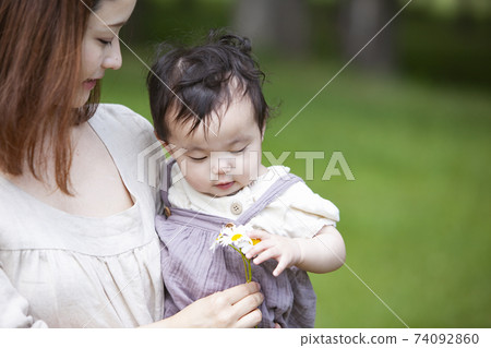 Parent and child playing in the park Parent and child playing in the park 74092860