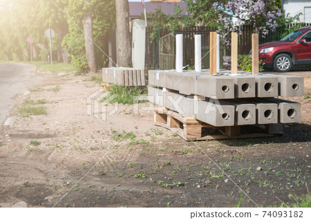 Concrete fence posts on wooden pallets. Improvement and repair works Concrete fence posts on wooden pallets. Improvement and repair works 74093182