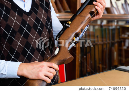 Closeup of sporting air PCP pump-action rifle in male hands 74094830