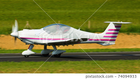 Sports airplane in motion over runway 74094933