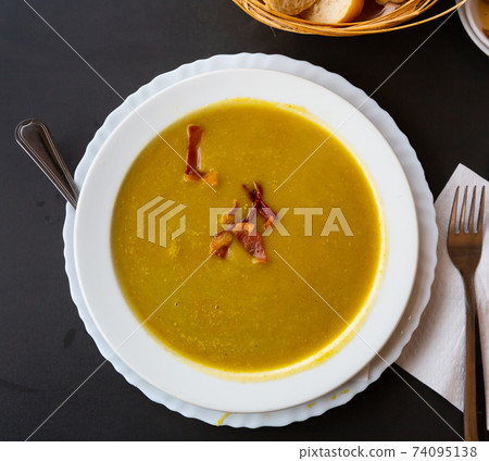 Cream soup of vegetables garnished with gammon slices Cream soup of vegetables garnished with gammon slices 74095138