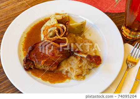Confit duck leg with sauerkraut and dumplings Confit duck leg with sauerkraut and dumplings 74095204