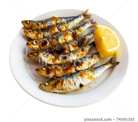 Espeto de sardinas with slice of lemon 74095385