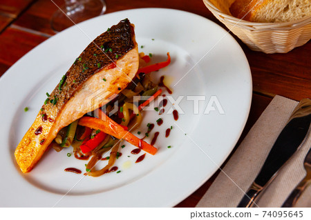 Grilled salmon steak with sauteed vegetables Grilled salmon steak with sauteed vegetables 74095645