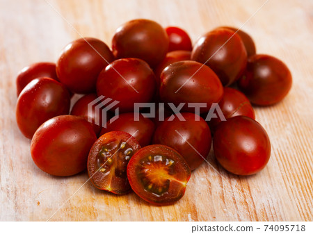 Cherry tomatoes on wooden table 74095718