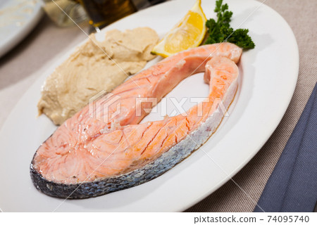 Dish of tasty steak of low-fried salmon served with hummus Dish of tasty steak of low-fried salmon served with hummus 74095740