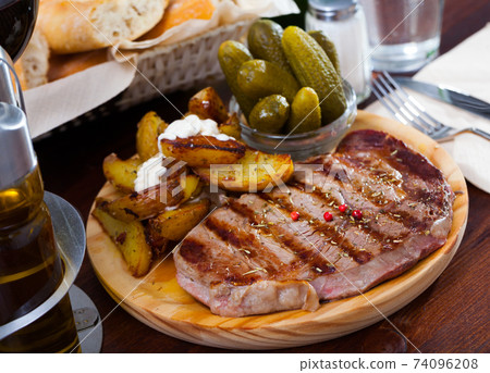 Appetizing beef entrecote with boiled potatoes and pickled cucumbers Appetizing beef entrecote with boiled potatoes and pickled cucumbers 74096208