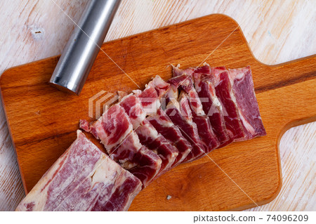 Sliced lacon curado on wooden background 74096209