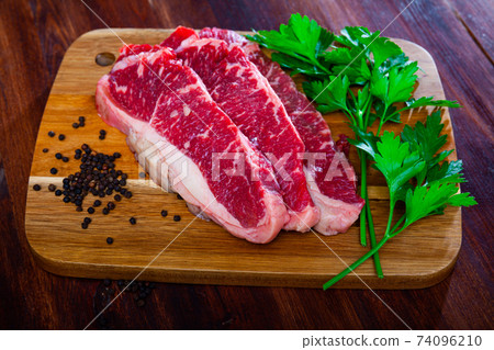 Raw beef tenderloin with spices on cutting board Raw beef tenderloin with spices on cutting board 74096210