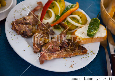 Image of tasty lamb baked and served with bread and vegetables Image of tasty lamb baked and served with bread and vegetables 74096211