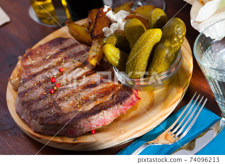 Beef entrecote with spices on a wooden round board Beef entrecote with spices on a wooden round board 74096213