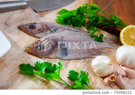 Raw fresh rooster fish before cooking on wooden desk 74096222