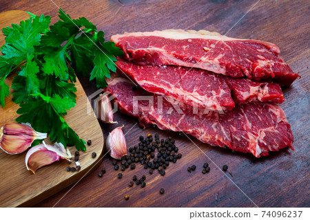 Raw marbled beef entrecotes with parsley and spices Raw marbled beef entrecotes with parsley and spices 74096237