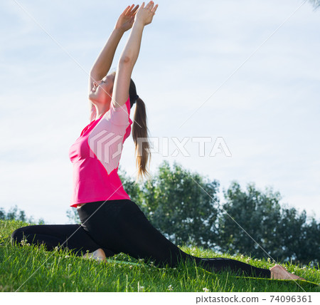 Female 20-30 years old is practicing stretching in pink T-shirt 74096361