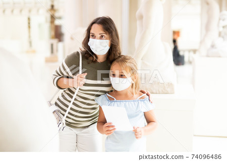 Mom and her daughter in protective masks on tour of the museum Mom and her daughter in protective masks on tour of the museum 74096486