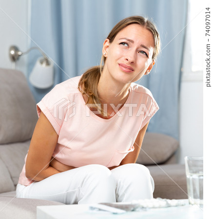 Unhappy female having stomachache Unhappy female having stomachache 74097014