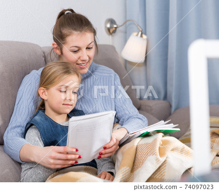 Woman helping her daughter with hometask Woman helping her daughter with hometask 74097023