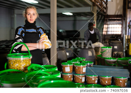 Confident workwoman on pickled olives factory 74097036