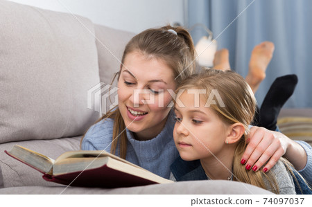 Mother and daughter reading at home Mother and daughter reading at home 74097037