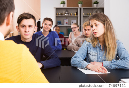 Students listening attentively teacher’s lecture Students listening attentively teacher’s lecture 74097131