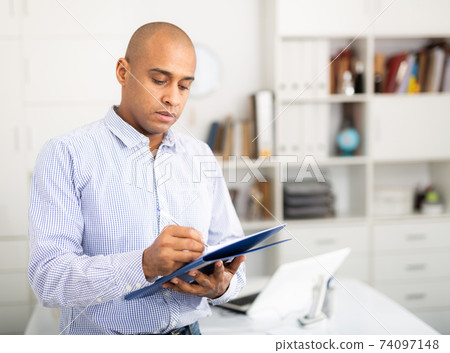 Businessman makes notes in the document at office 74097148