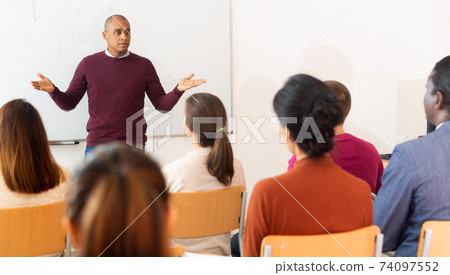 Teacher standing in front of interactive whiteboard teaching lesson 74097552