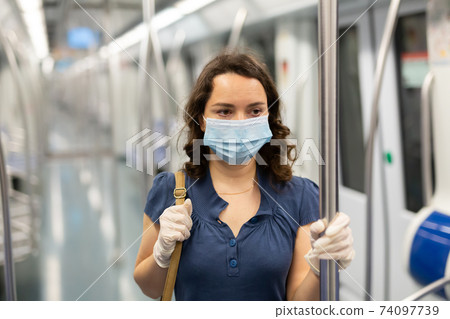 Woman in disposable mask in subway train 74097739