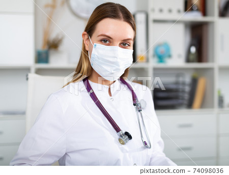Female doctor in lab coat and protective medical masks Female doctor in lab coat and protective medical masks 74098036