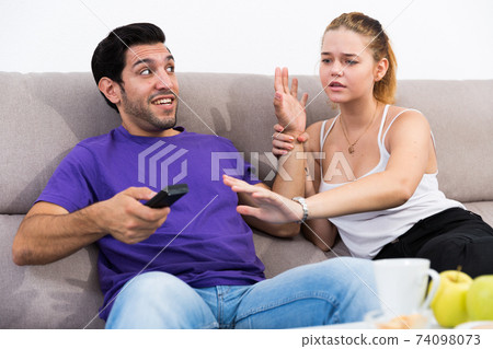 Couple arguing because of TV remote Couple arguing because of TV remote 74098073