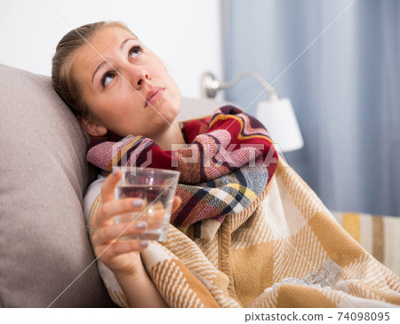 Unhealthy female is sitting in a plaid with medications 74098095