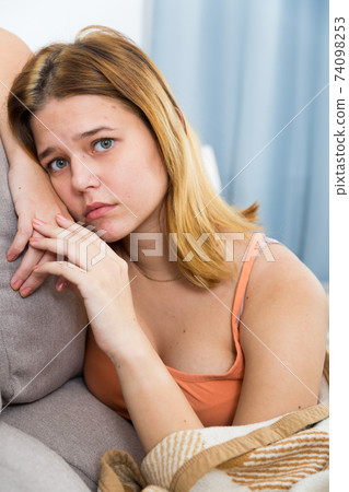 sad female on cozy sofa at home 74098253