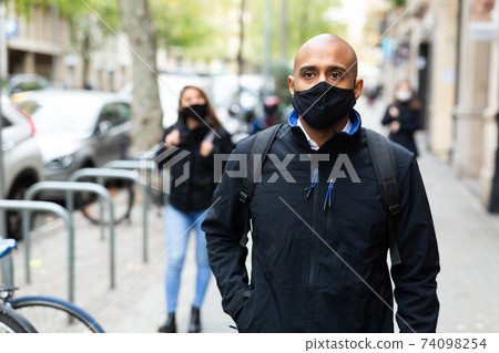 Man in black protective mask on street Man in black protective mask on street 74098254