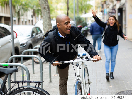 Man stealing bicycle, woman owner running after Man stealing bicycle, woman owner running after 74098291
