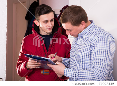 Man is writing documents about deliver order by courier Man is writing documents about deliver order by courier 74098336