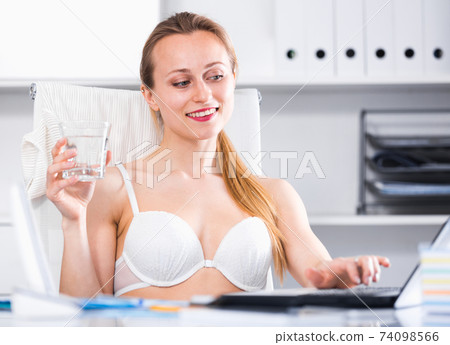 Cheerful woman in bra working Cheerful woman in bra working 74098566