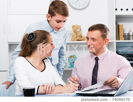 Mother and son signing documents Mother and son signing documents 74098570