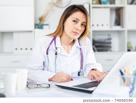 Female doctor working on laptop in office Female doctor working on laptop in office 74098590