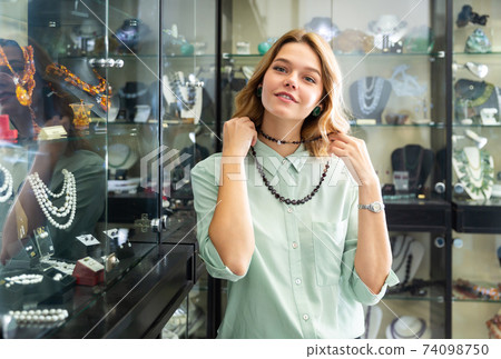 Female client trying on beads from dark garnet Female client trying on beads from dark garnet 74098750