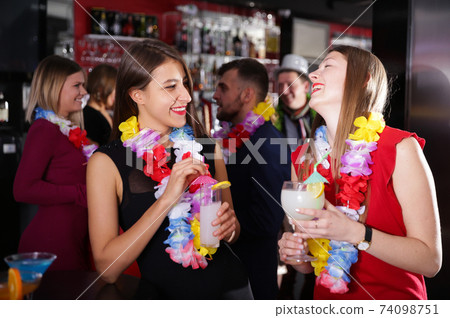 Girls on Hawaiian party in bar Girls on Hawaiian party in bar 74098751
