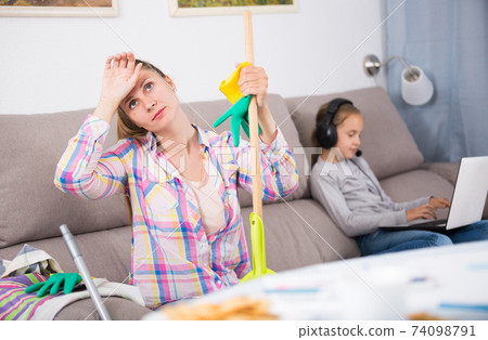 Tired mother sitting with mop Tired mother sitting with mop 74098791