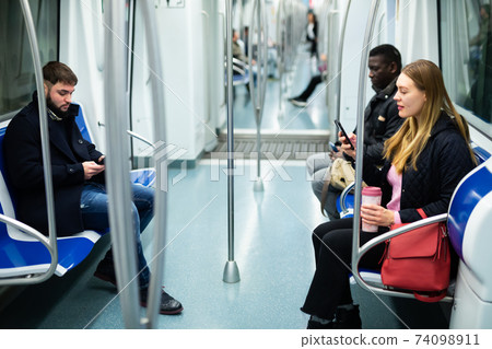People traveling in subway car 74098911