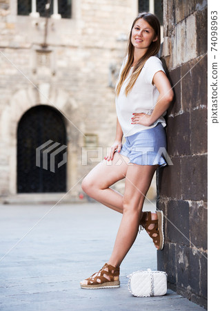 Romantic girl leaning against stone wall Romantic girl leaning against stone wall 74098963